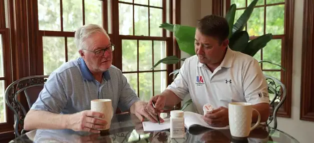 Jeff and man sitting and talking at a table